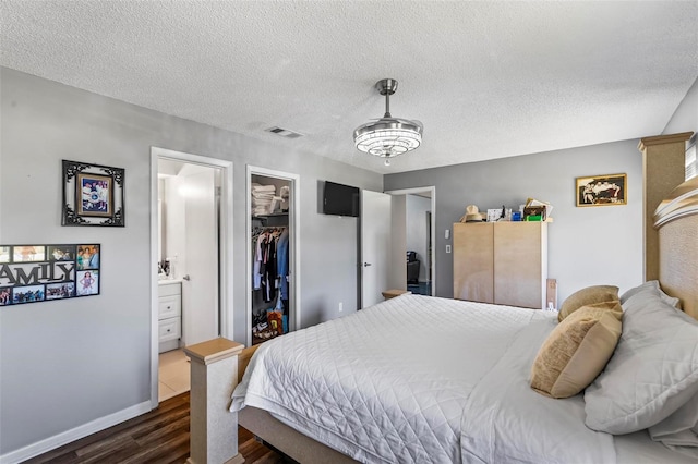 13 Belleaire Dr, Palm Coast, FL 32137 - bedroom with a textured ceiling, visible vents, wood finished floors, baseboards, and ensuite bath