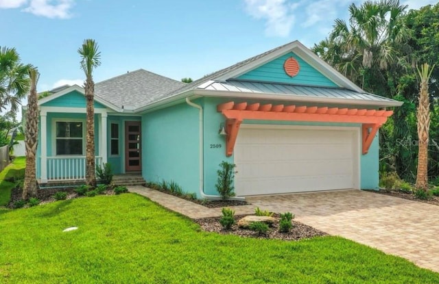 view of front facade with a front yard, stucco siding, an attached garage, driveway, and a porch