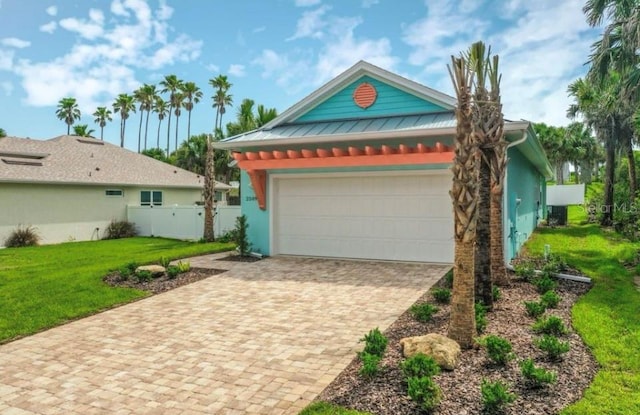 view of front of house featuring driveway, a front yard, a garage, fence, and stucco siding