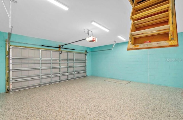 garage with concrete block wall and a garage door opener
