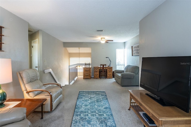 living area with a ceiling fan, carpet flooring, a textured ceiling, and visible vents