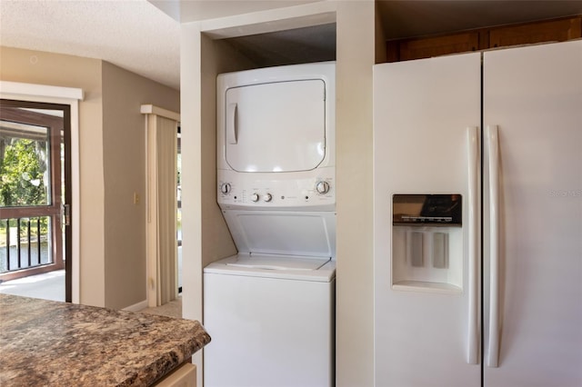 washroom featuring stacked washer / drying machine and laundry area