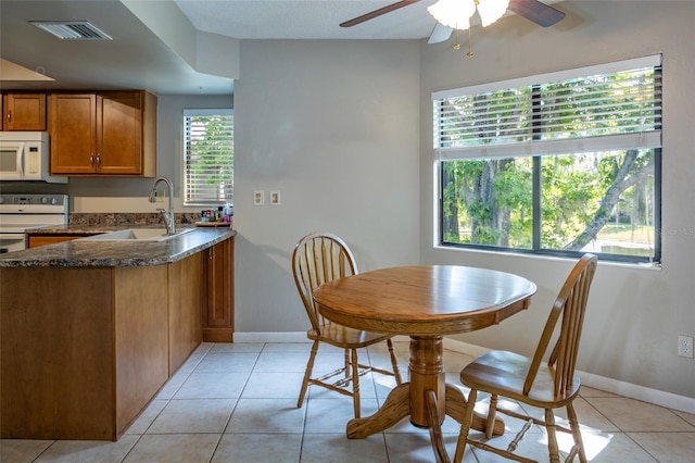 dining room with visible vents, a ceiling fan, baseboards, and light tile patterned floors