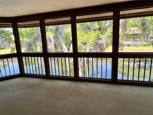 unfurnished sunroom featuring a water view and a wealth of natural light