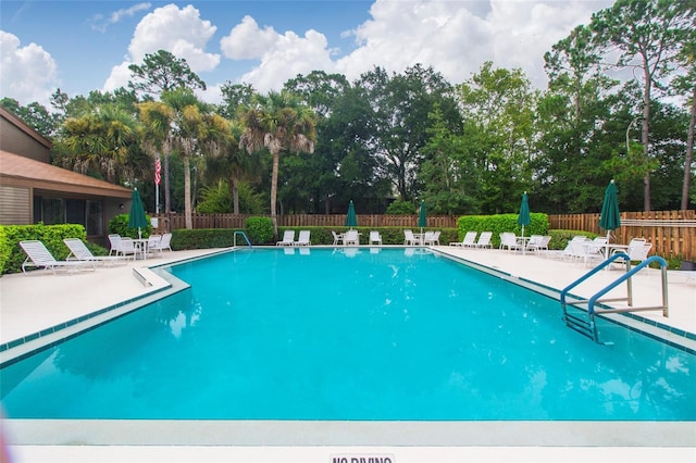 community pool featuring a patio and fence