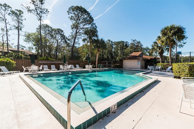 pool with a patio and fence