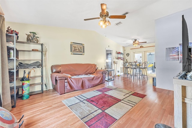 living area featuring ceiling fan, vaulted ceiling, wood finished floors, and visible vents