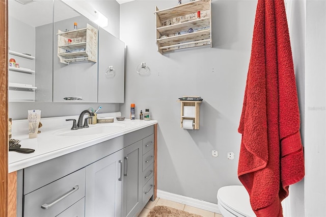 bathroom featuring tile patterned flooring, baseboards, toilet, and vanity