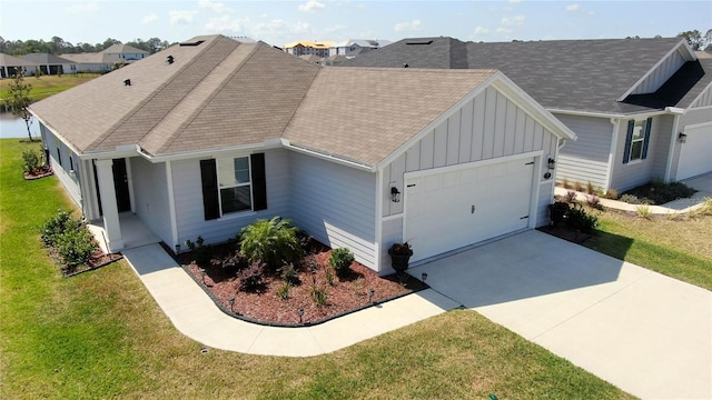 7 Windsor Ter, Palm Coast, FL 32164 - view of front facade with board and batten siding, driveway, roof with shingles, a garage, and a front lawn