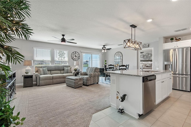 7 Windsor Ter, Palm Coast, FL 32164 - kitchen featuring a ceiling fan, light carpet, open floor plan, a sink, and stainless steel appliances