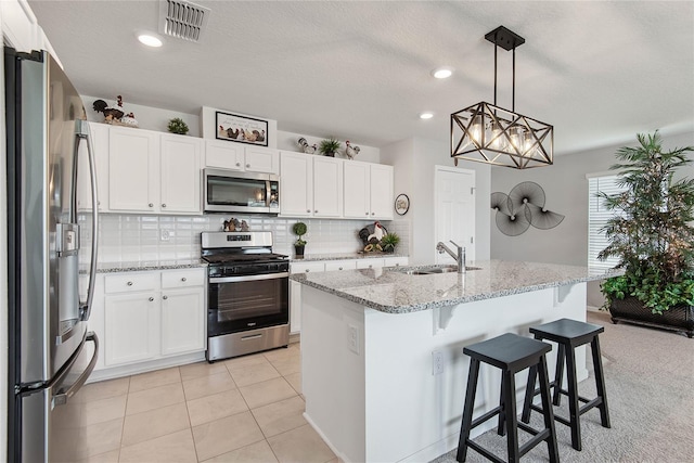 7 Windsor Ter, Palm Coast, FL 32164 - kitchen with decorative backsplash, light stone countertops, a sink, white cabinets, and stainless steel appliances