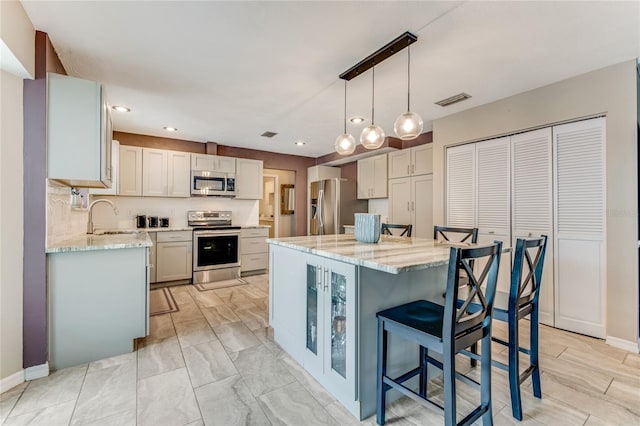 11 Larisa Ter, Ormond Beach, FL 32174 - kitchen with a breakfast bar area, recessed lighting, light stone counters, a sink, and appliances with stainless steel finishes