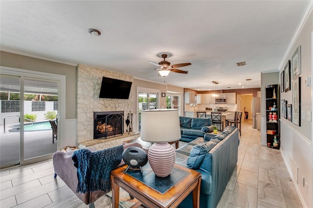 11 Larisa Ter, Ormond Beach, FL 32174 - living room featuring crown molding, ceiling fan, a stone fireplace, and a wealth of natural light