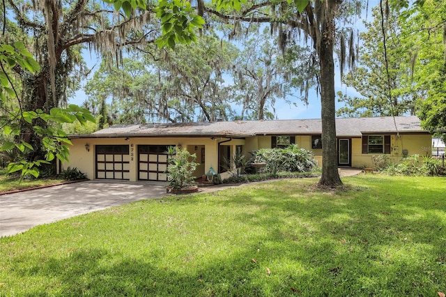 ranch-style house with an attached garage, driveway, stucco siding, and a front yard