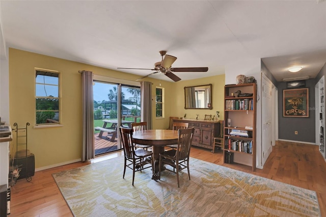 dining area featuring a ceiling fan, baseboards, and light wood-type flooring