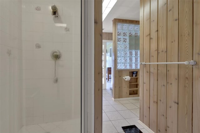 full bath featuring wood walls, tile patterned flooring, and a stall shower