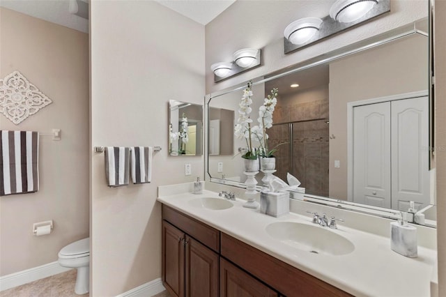full bathroom featuring baseboards, a sink, a stall shower, and toilet