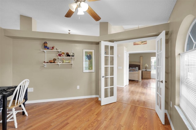 office featuring french doors, baseboards, ceiling fan, and light wood-type flooring