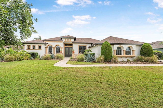 mediterranean / spanish-style home featuring french doors, a front yard, and stucco siding