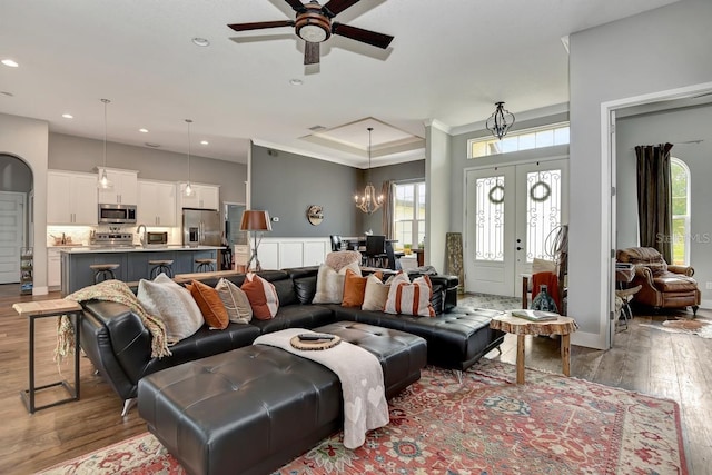 living room featuring french doors, ceiling fan with notable chandelier, recessed lighting, and hardwood / wood-style floors