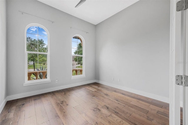 unfurnished room featuring baseboards and hardwood / wood-style floors