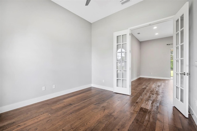 spare room featuring ceiling fan, french doors, visible vents, baseboards, and dark wood-type flooring