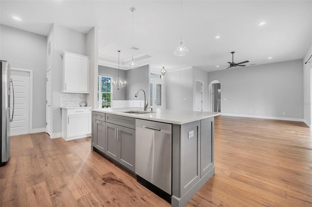 kitchen with light wood-type flooring, a sink, light countertops, gray cabinetry, and stainless steel appliances