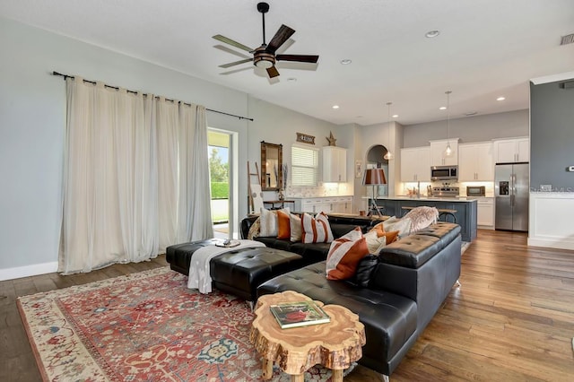 living area with a ceiling fan, recessed lighting, visible vents, and hardwood / wood-style floors