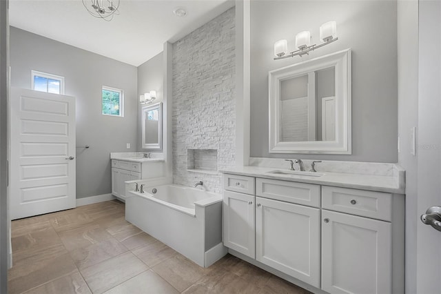 bathroom with a sink, baseboards, a garden tub, and two vanities