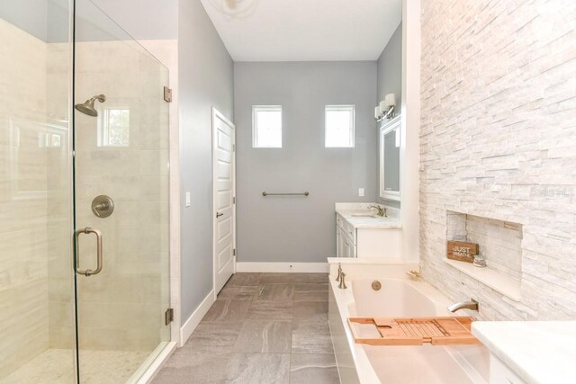 bathroom featuring a bath, a stall shower, vanity, baseboards, and marble finish floor