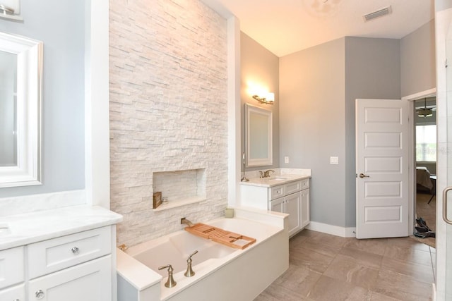 full bath featuring visible vents, marble finish floor, a bath, two vanities, and a sink