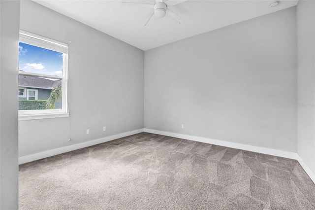 carpeted empty room featuring baseboards and a ceiling fan