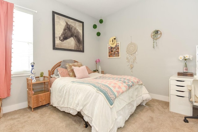 bedroom with baseboards and light colored carpet
