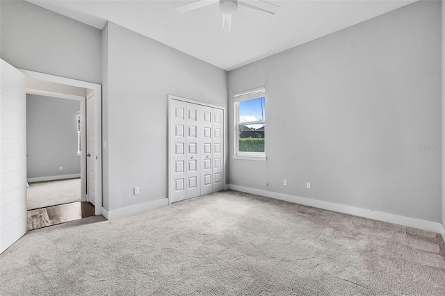 unfurnished bedroom featuring carpet flooring, baseboards, ceiling fan, and a closet
