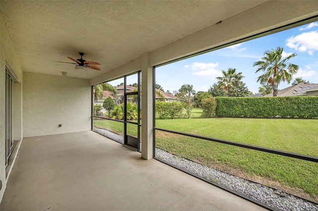 unfurnished sunroom featuring a ceiling fan