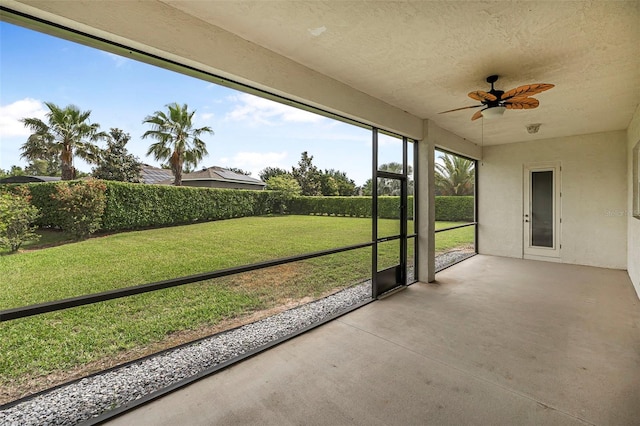 unfurnished sunroom featuring ceiling fan