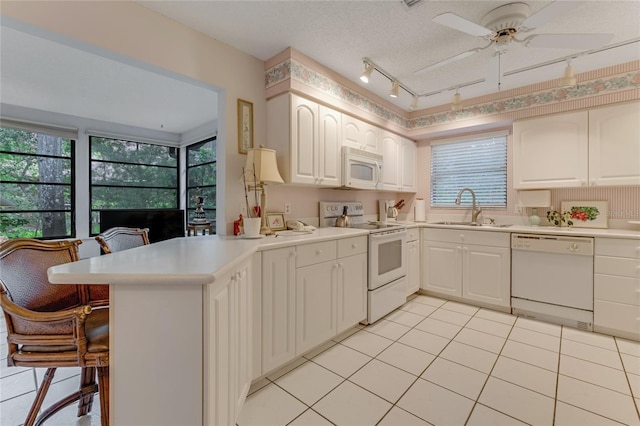 15 Morning Dew Trl, Ormond Beach, FL 32174 - kitchen featuring white appliances, a sink, a breakfast bar, a peninsula, and light countertops