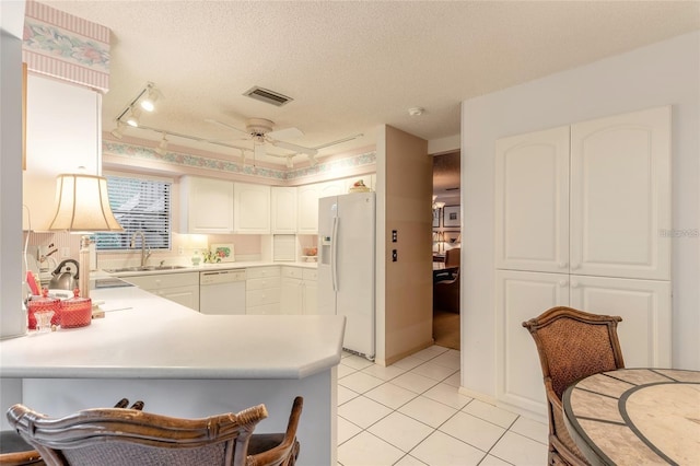 15 Morning Dew Trl, Ormond Beach, FL 32174 - kitchen with white appliances, a sink, a peninsula, light tile patterned flooring, and white cabinetry