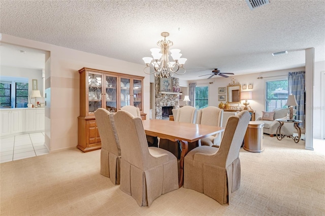 15 Morning Dew Trl, Ormond Beach, FL 32174 - dining area featuring light carpet, a fireplace, a chandelier, ceiling fan, and a textured ceiling