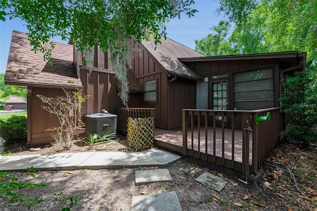 15 Morning Dew Trl, Ormond Beach, FL 32174 - rear view of house featuring a shingled roof, cooling unit, a wooden deck, and board and batten siding