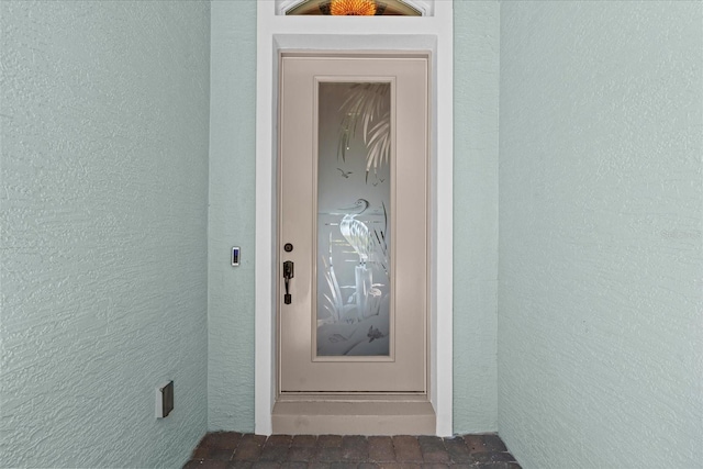 entrance to property featuring stucco siding