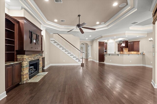 unfurnished living room featuring crown molding, a fireplace, a ceiling fan, and visible vents