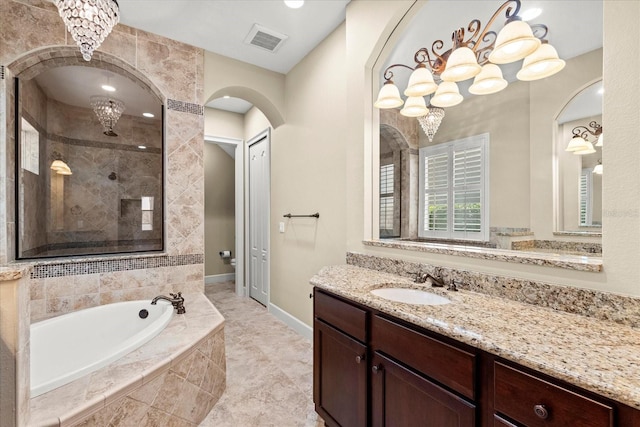full bath featuring a garden tub, visible vents, a tile shower, vanity, and a chandelier