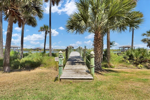 view of home's community with a water view and a yard