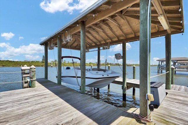 dock area with boat lift and a water view