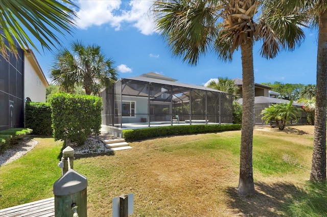 view of yard with glass enclosure and an outdoor pool