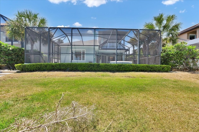 back of house with a yard and glass enclosure