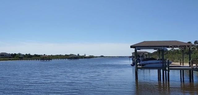 dock area with a water view and boat lift