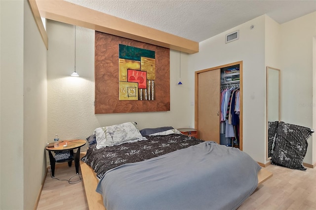 101 Palm Harbor Pkwy Unit A303, Palm Coast, FL 32137 - bedroom featuring wood finished floors, a closet, and a textured ceiling