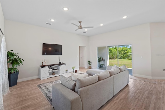 living room featuring visible vents, light wood-style floors, ceiling fan, and baseboards